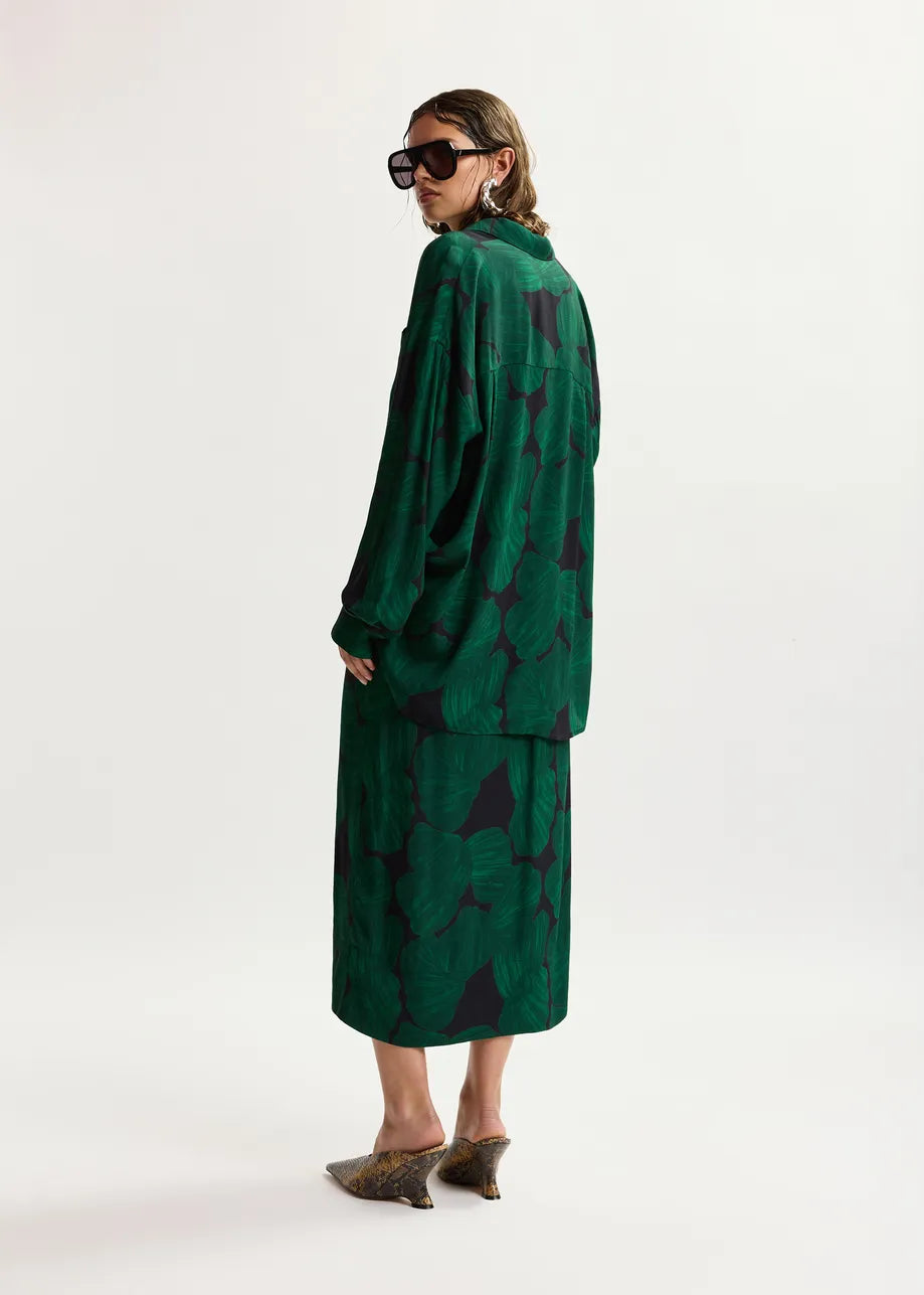 Woman wearing a green patterned dress on a white background