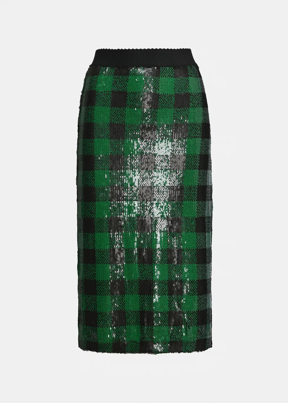 A close-up of a green and black sequin plaid pattern on a skirt, showing the reflective texture of the sequins.