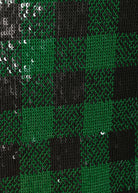 A close-up of a green and black sequin plaid pattern, showing the reflective texture of the sequins.