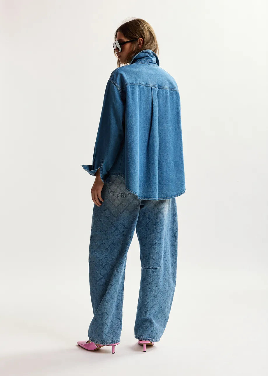 Person wearing a blue denim outfit on a white background