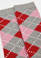 A pair of gray crew socks with an argyle pattern in red, pink, and white on the upper portion, and solid gray on the lower half.