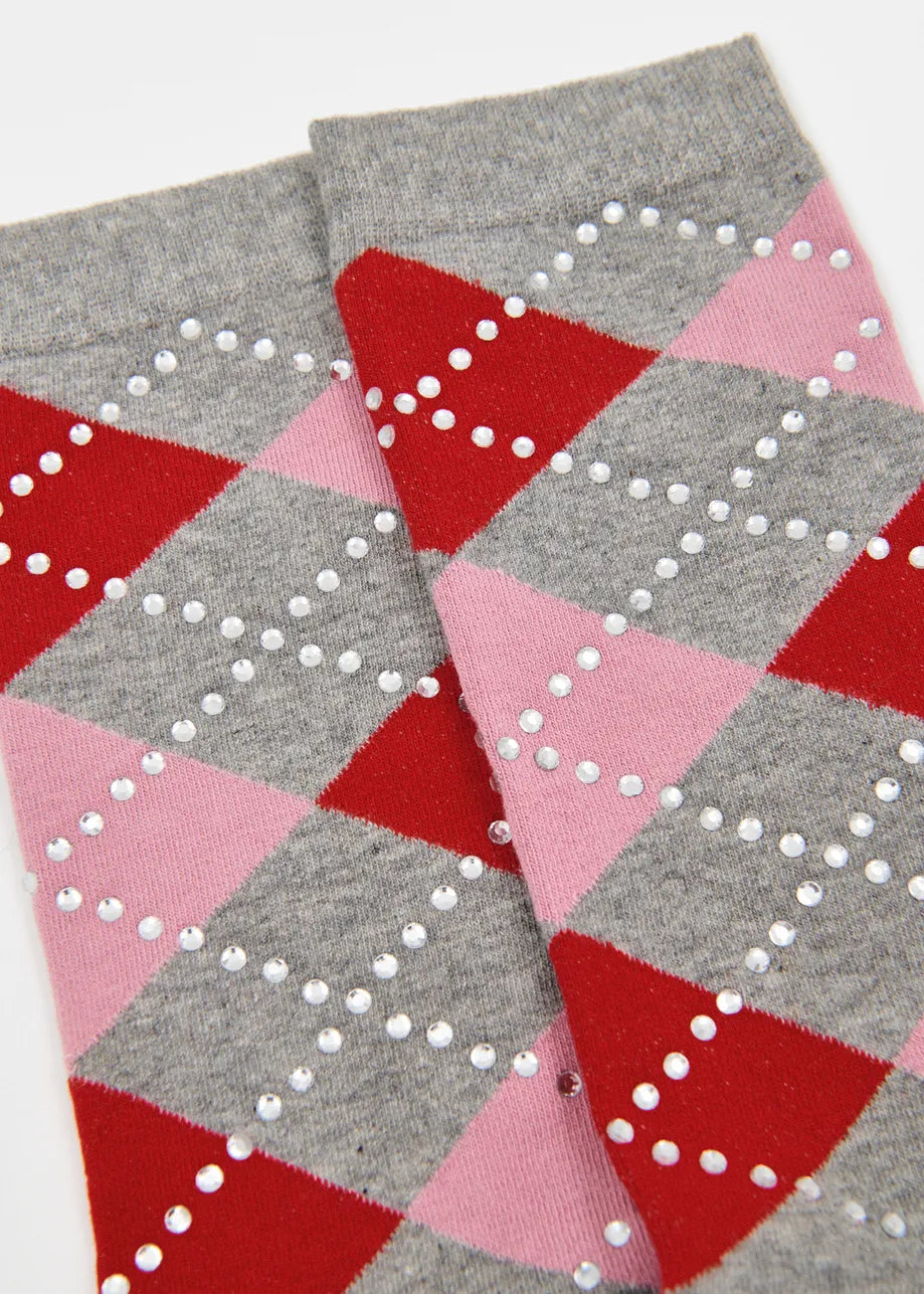 A pair of gray crew socks with an argyle pattern in red, pink, and white on the upper portion, and solid gray on the lower half.
