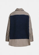 A navy blue knit vest layered over a beige, brown, and white gingham shirt, featuring a pointed collar and three silver buttons on the front, set against a plain light gray background from the back perspective.