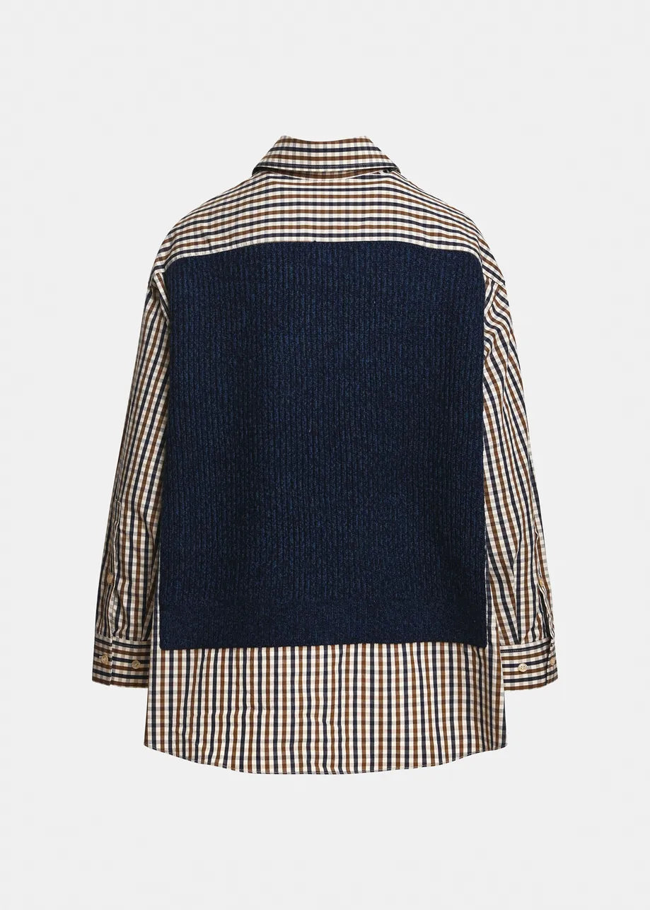 A navy blue knit vest layered over a beige, brown, and white gingham shirt, featuring a pointed collar and three silver buttons on the front, set against a plain light gray background from the back perspective.