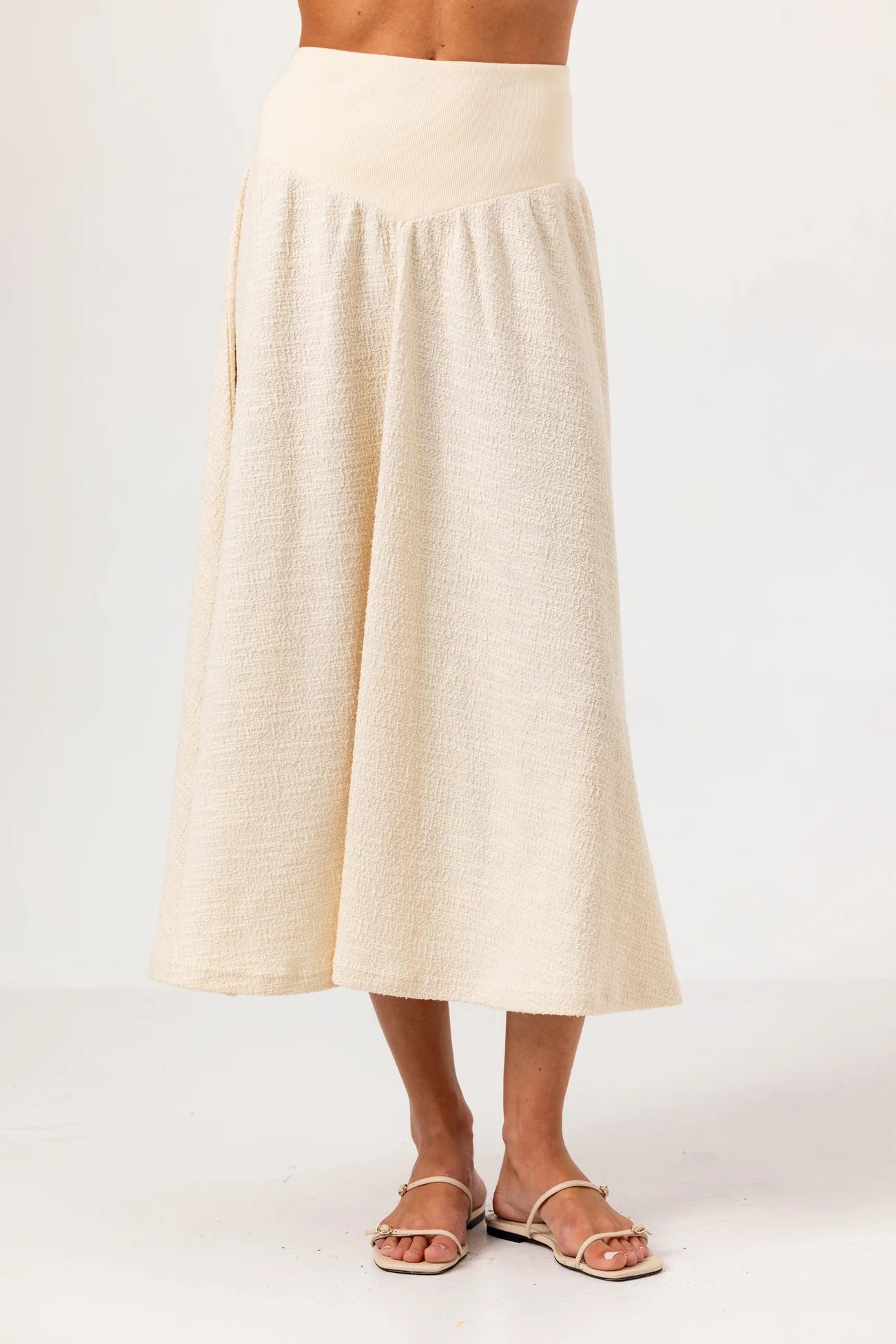 Beige skirt worn by a person on a white background