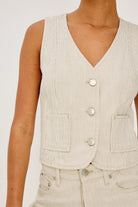 Beige striped vest worn by a person on a white background