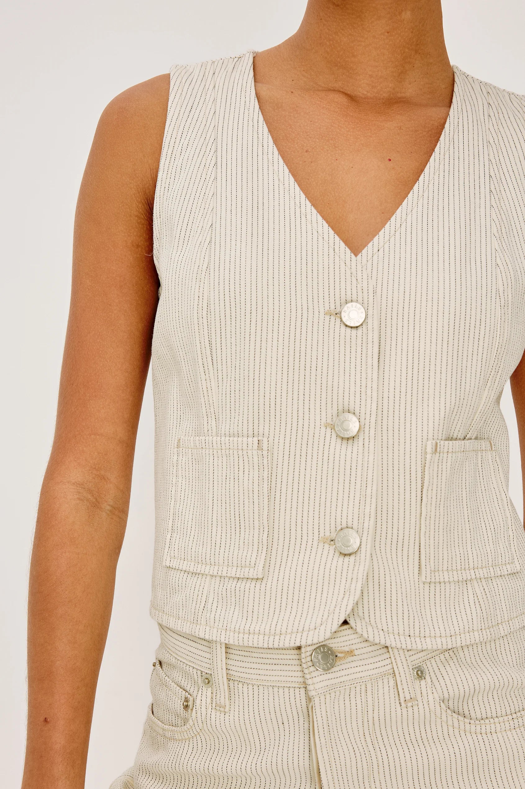 Beige striped vest worn by a person on a white background