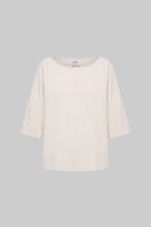 An off-white three-quarter sleeve top with a wide boat neckline, displayed against a solid gray background.
