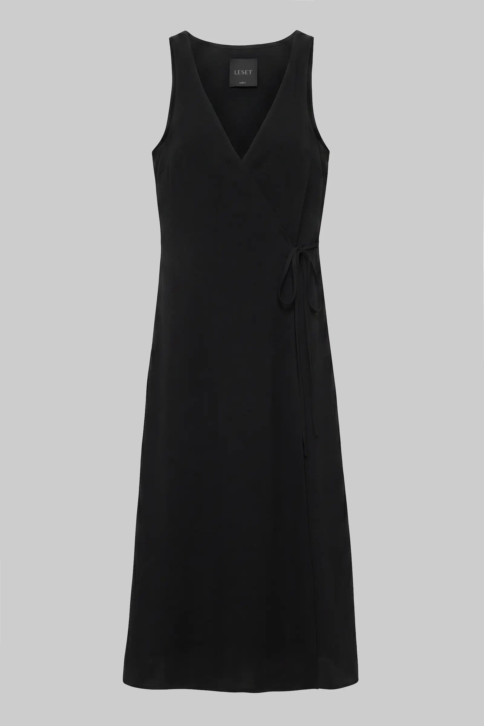 A black sleeveless wrap-style midi dress with a V-neckline and a self-tie waist, shown against a solid gray background.