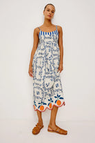 Woman wearing a floral dress with a blue and white striped top on a white background