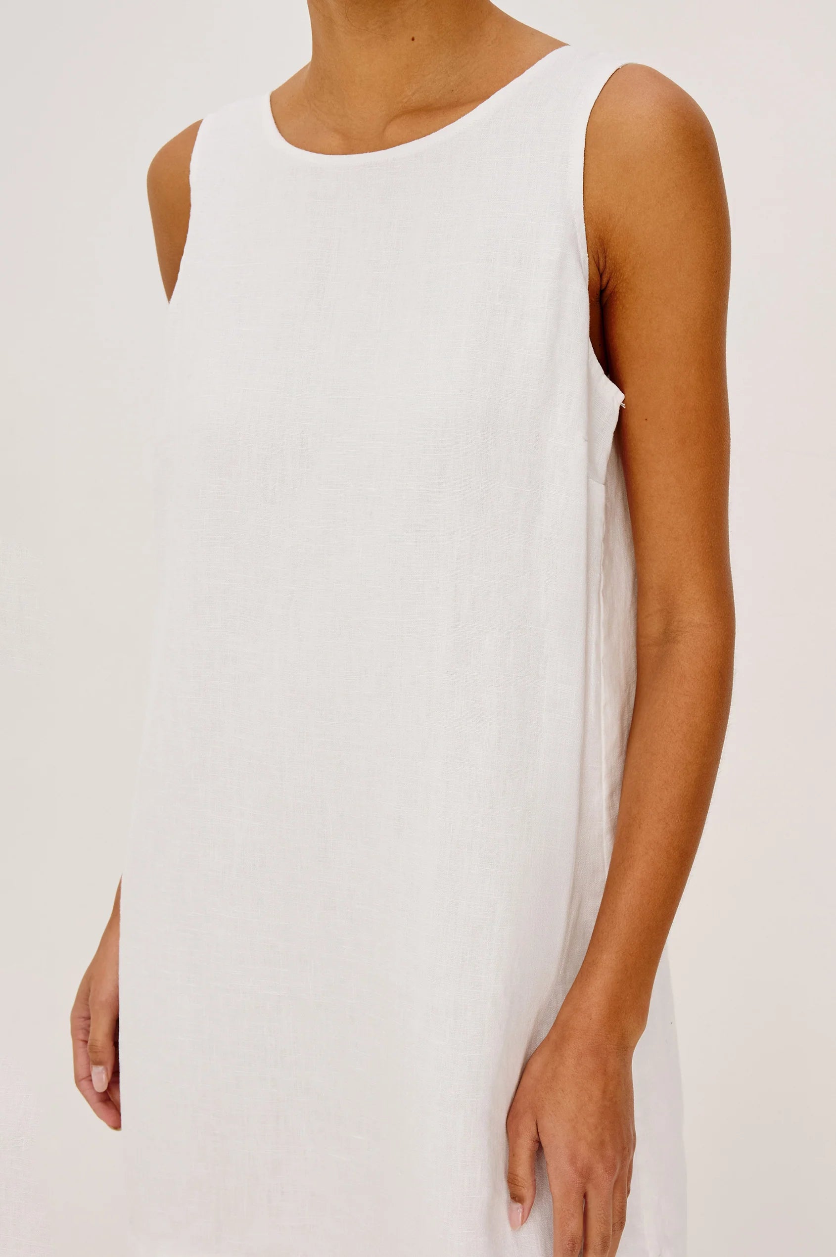 White sleeveless dress worn by a person on a plain background