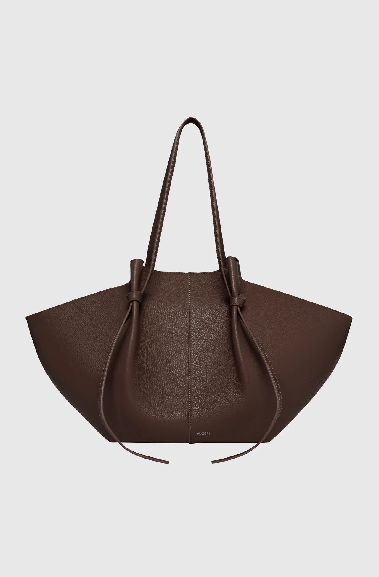 Brown leather handbag on a light gray background