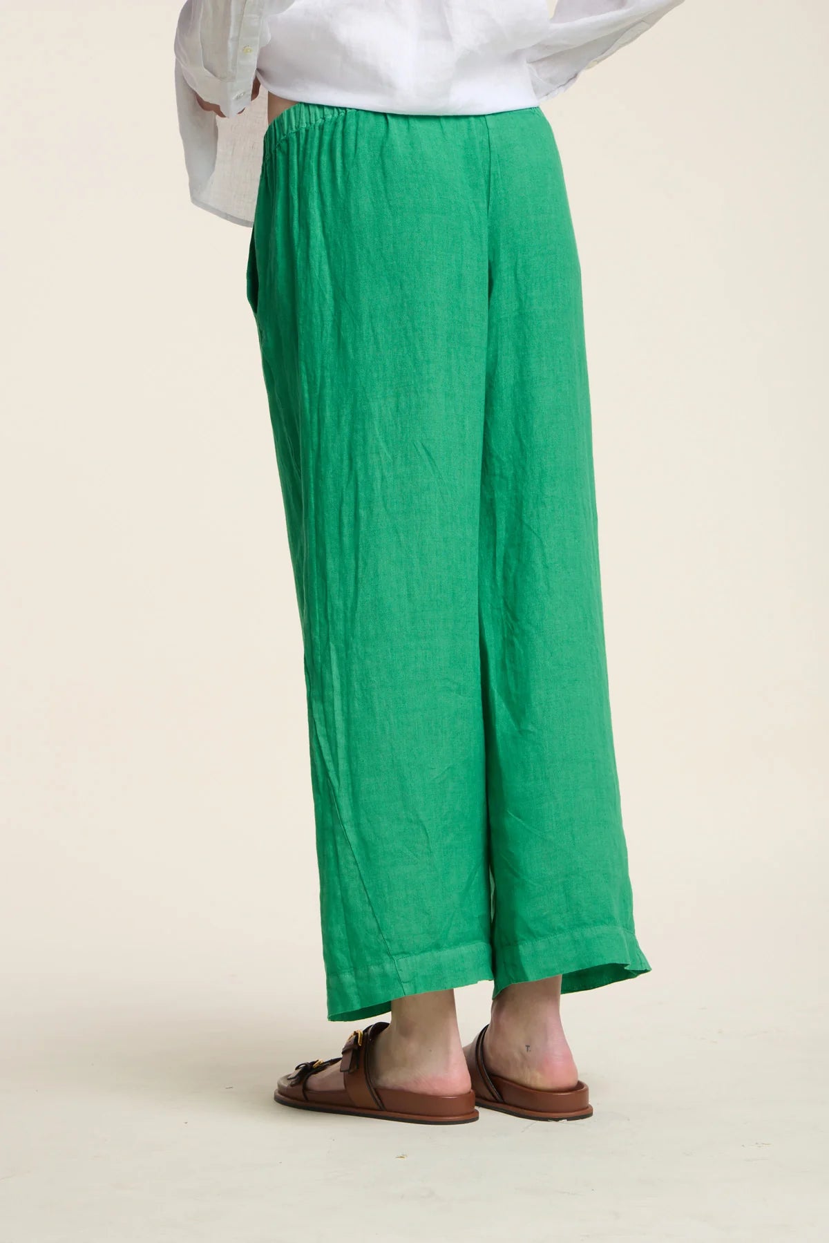 Green wide-leg pants worn by a person on a plain background