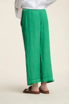 Green wide-leg pants worn by a person on a plain background