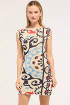 Woman wearing a sleeveless dress with a colorful abstract pattern on a white background