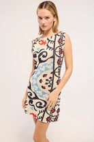 Woman wearing a patterned dress on a plain background