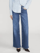 Person wearing blue jeans and a light blue shirt on a white background
