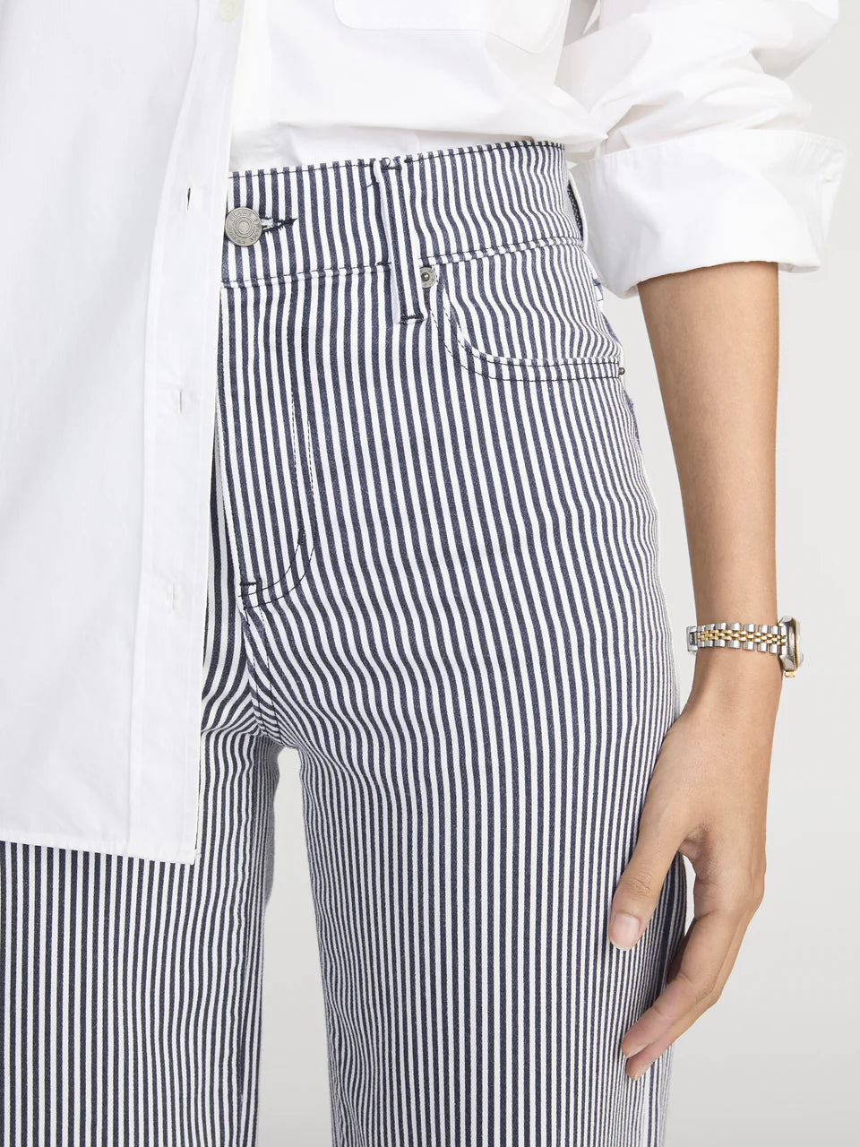 Person wearing black and white striped pants with a white shirt.
