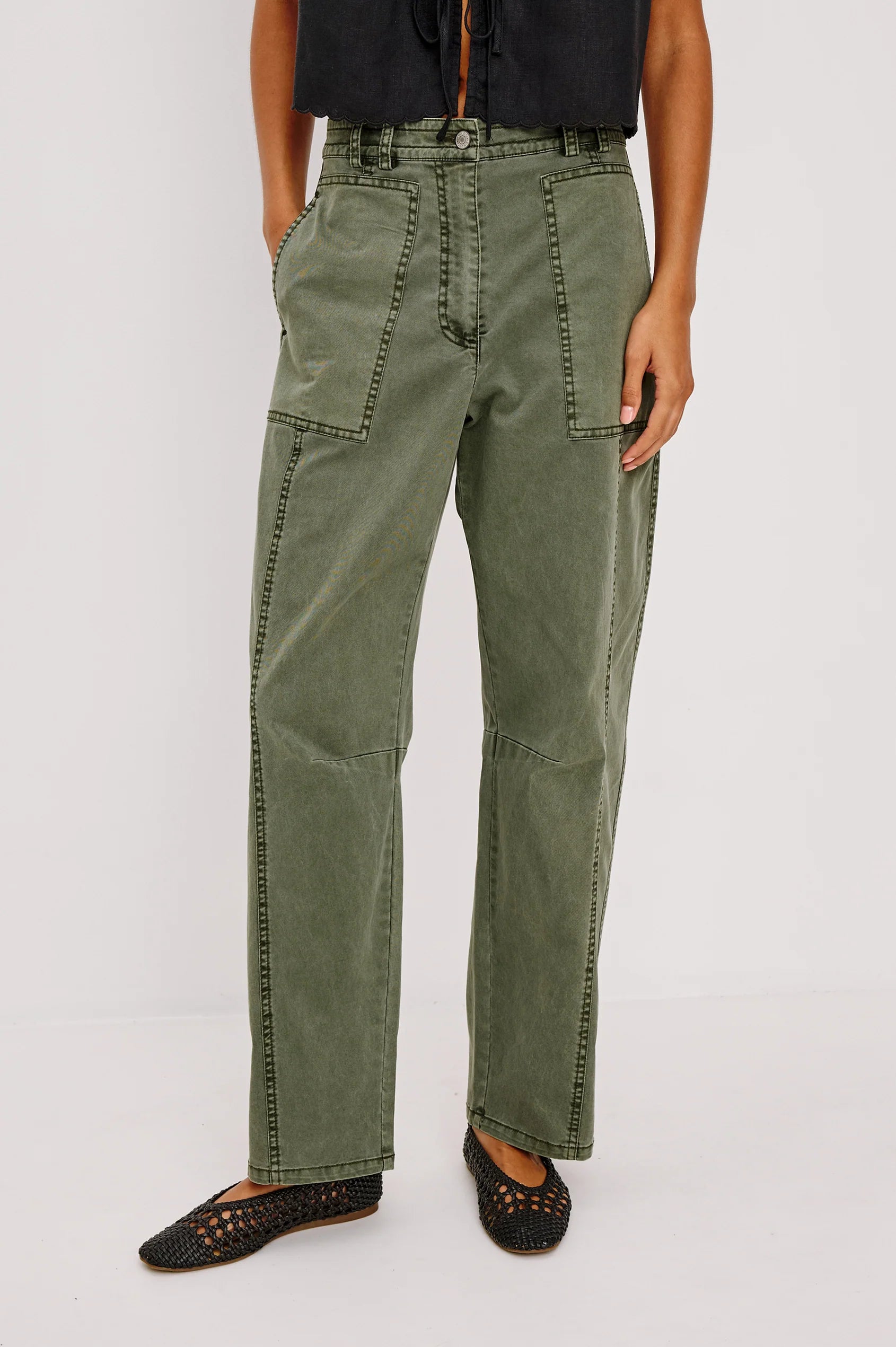 Person wearing olive green pants on a white background