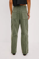 Person wearing olive green cargo pants on a white background