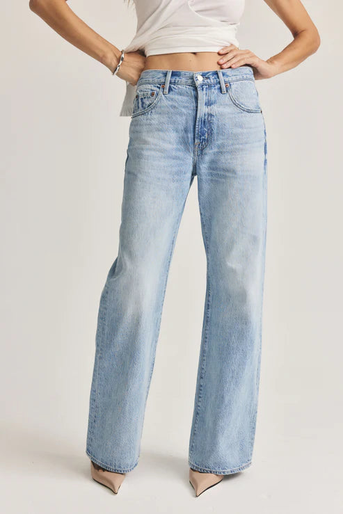 Light blue jeans worn by a person on a plain background