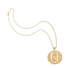 Gold necklace with a round pendant on a white background