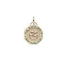 Gold pendant with a clover design and green gemstones on a white background