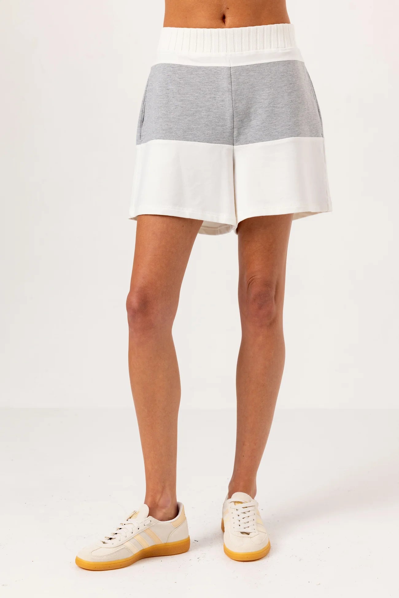 Person wearing a gray and white striped skirt on a plain background