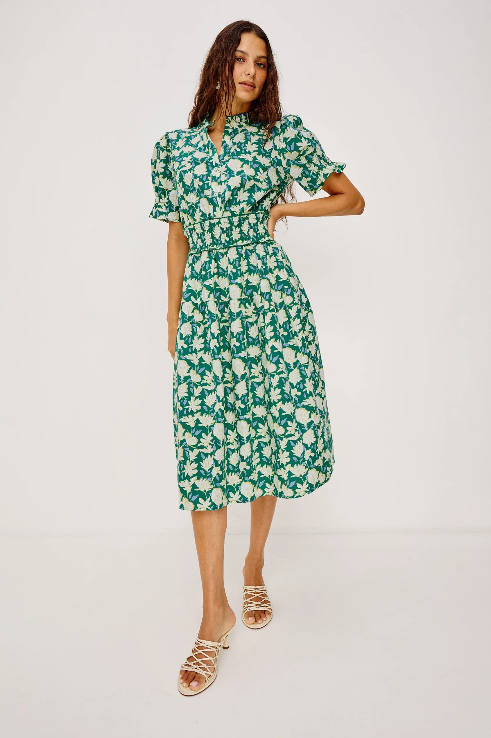 Woman wearing a green floral dress on a white background