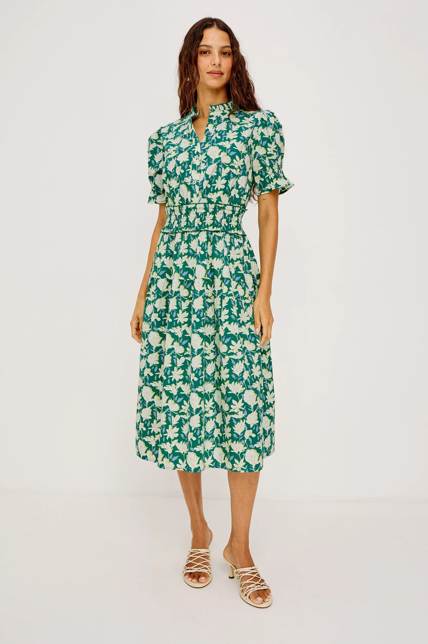 Woman wearing a green floral dress on a white background