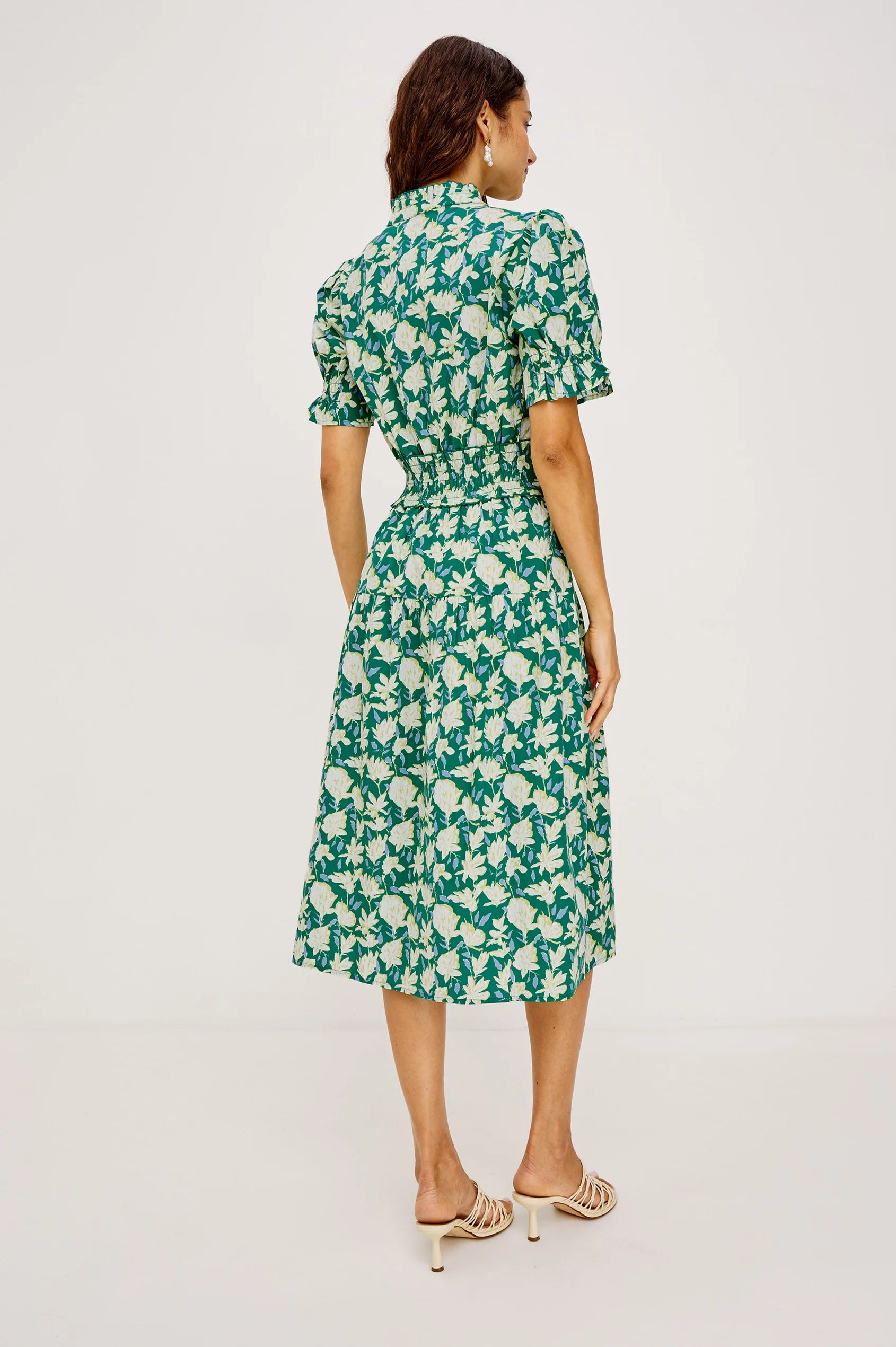 Woman wearing a green floral dress on a white background