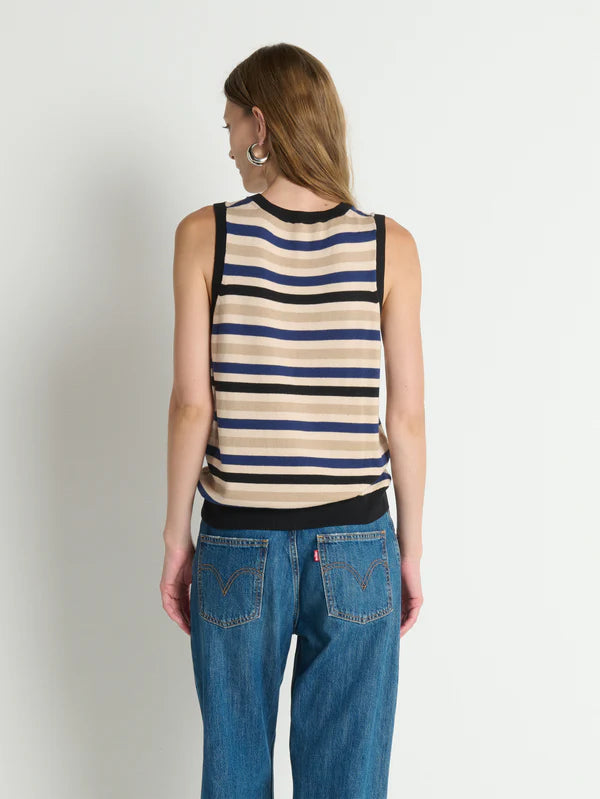 Woman wearing a striped tank top and blue jeans on a plain background