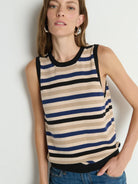 Woman wearing a striped tank top against a plain background