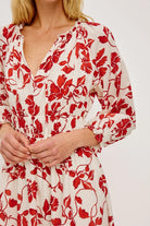 Red floral pattern on a white dress worn by a person