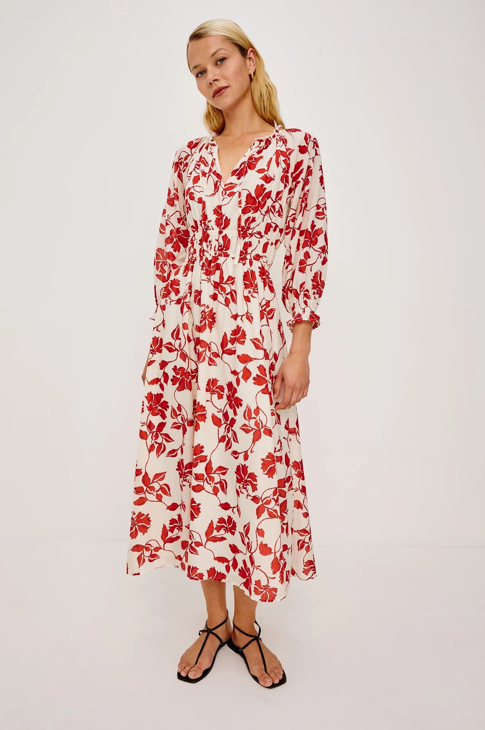 Woman wearing a red floral dress on a white background