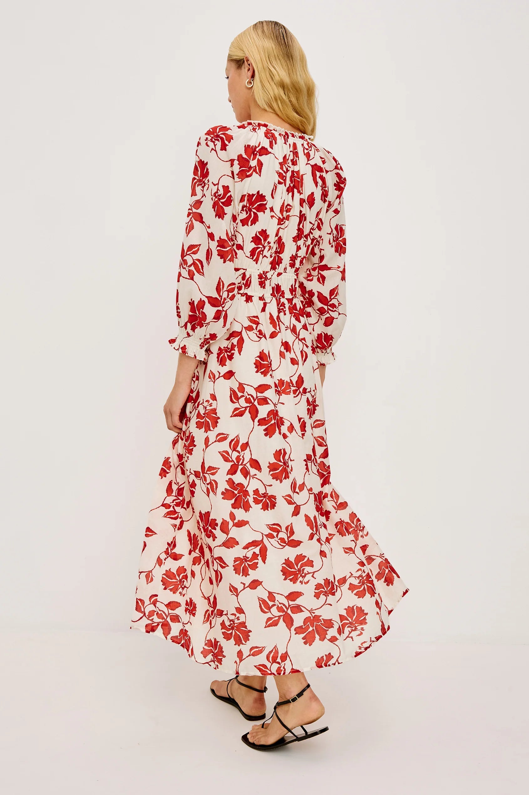 Woman wearing a red floral dress on a white background