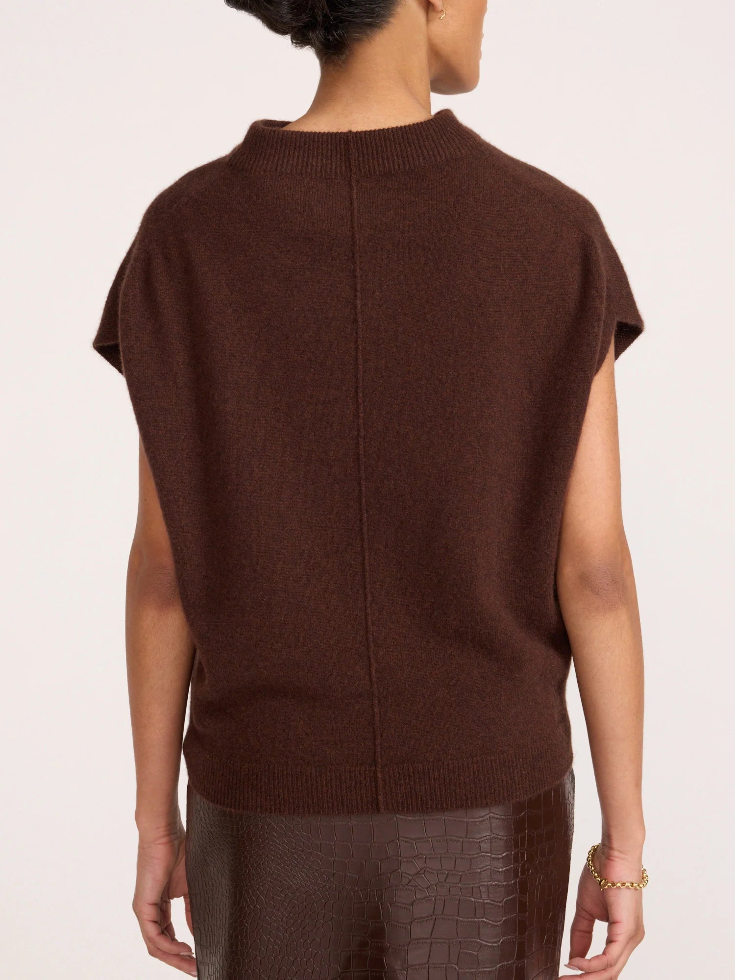 A person shown from the back wearing a dark brown short-sleeve knit sweater and matching brown textured pants against a plain light background.