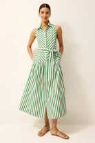 Woman wearing a green and white striped dress against a plain background