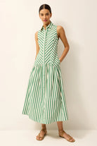 Woman wearing a green and white striped dress on a plain background