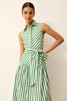 Woman wearing a green and white striped dress against a plain background