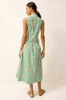 Woman wearing a green and white striped dress against a plain background