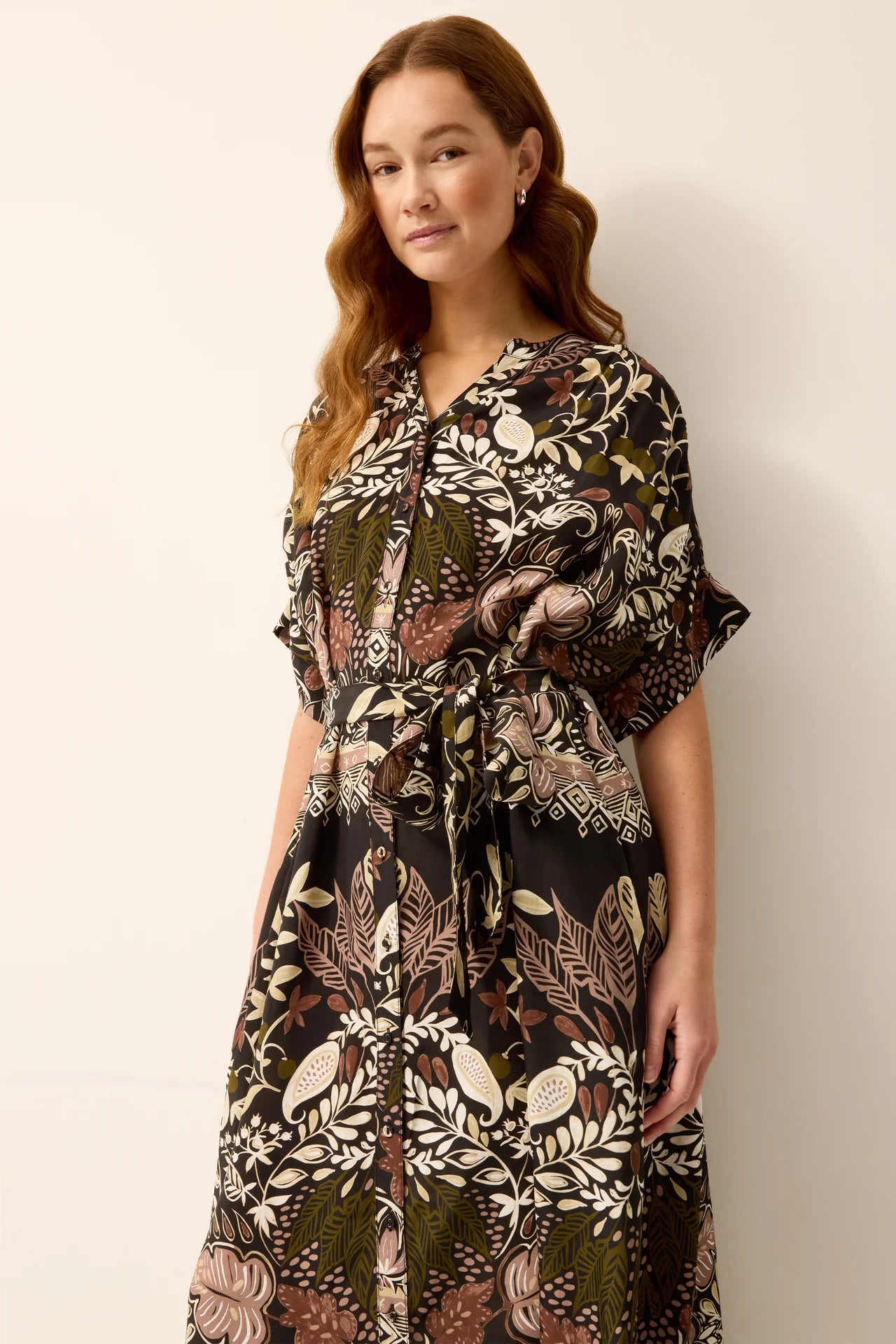 Woman wearing a patterned dress against a plain background