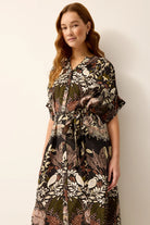 Woman wearing a patterned dress against a plain background
