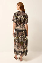 Woman wearing a patterned dress on a white background