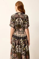Woman wearing a patterned dress on a plain background