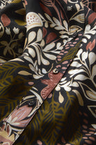Close-up of a patterned shirt with floral and abstract designs.