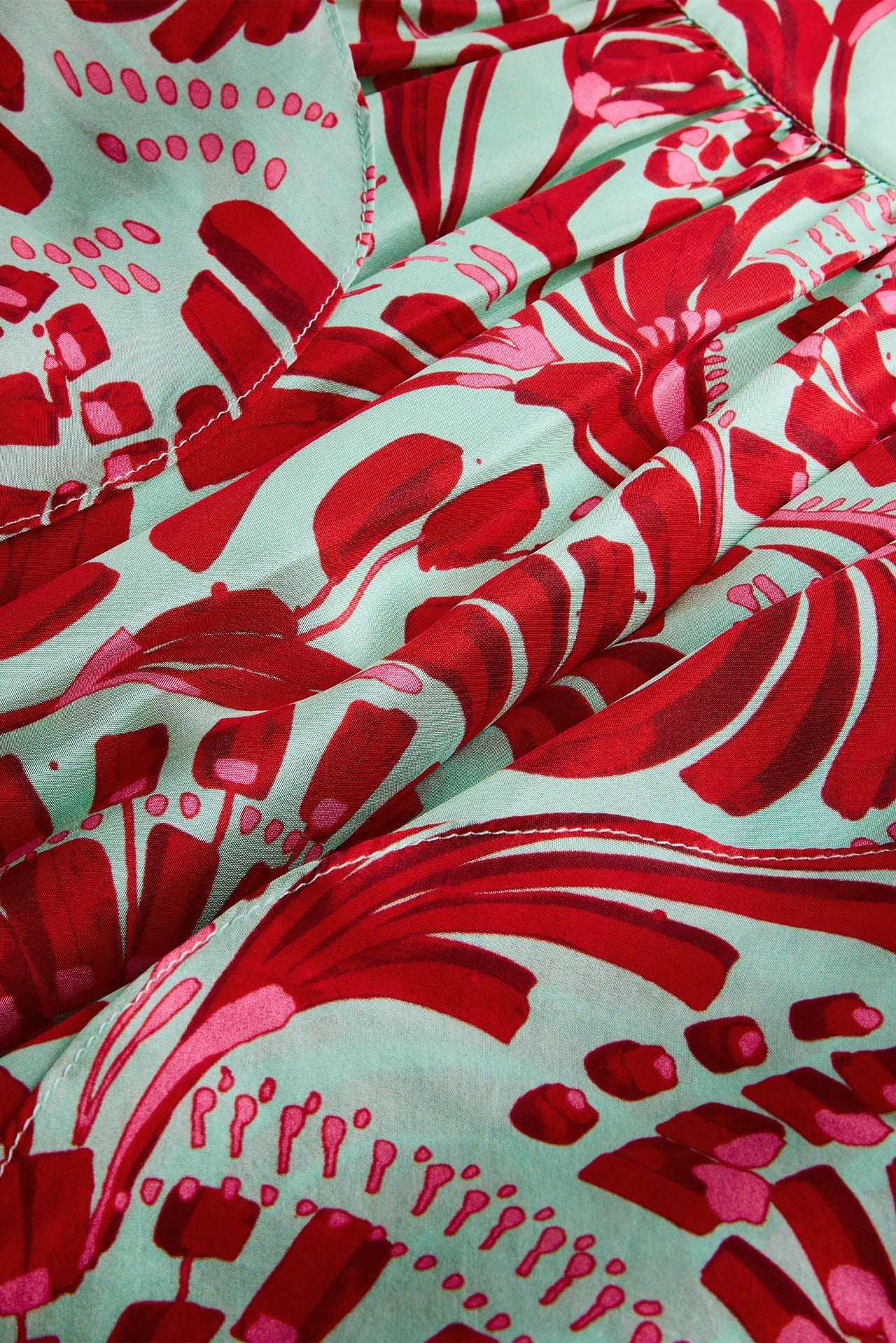 Close-up of red and pink floral pattern on a light blue background