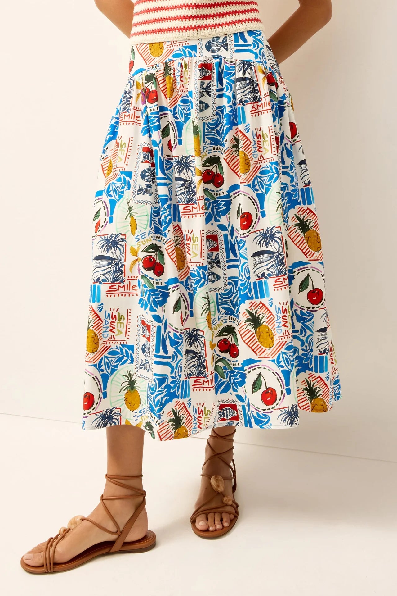 Person wearing a colorful tropical print skirt on a plain background