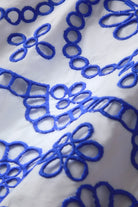 Close-up of blue embroidered pattern on white fabric