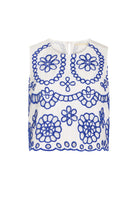 White sleeveless top with blue floral patterns on a white background